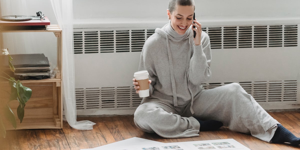 A UX designer sitting on the floor in their apartment, working on a passion project