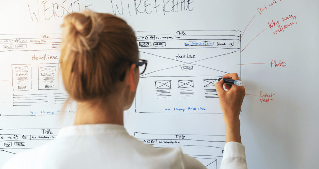 UI designer working on wireframes on a whiteboard