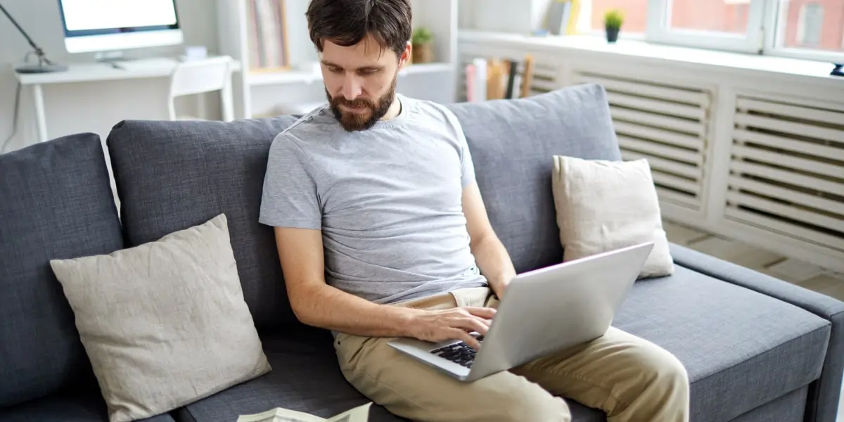 A data analyst sitting on a sofa with a laptop, running secondary data analysis