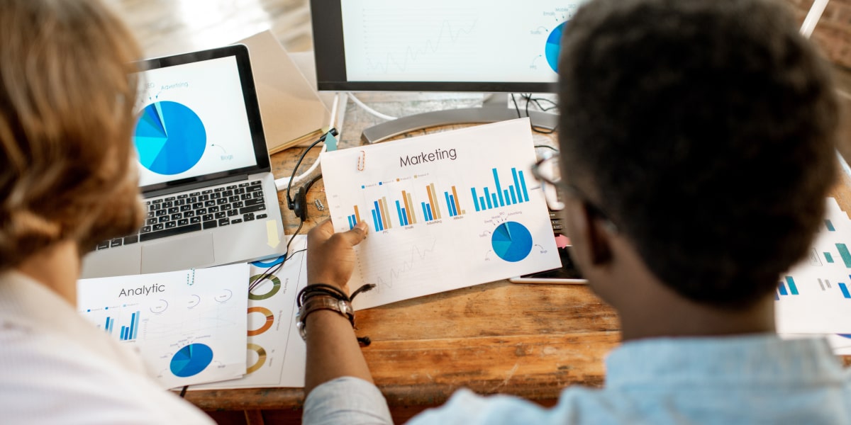 Two data analysts looking at graphs for secondary data analysis