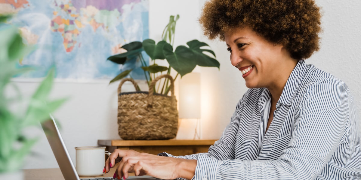 An SEO specialist in side profile, typing on a laptop, smiling