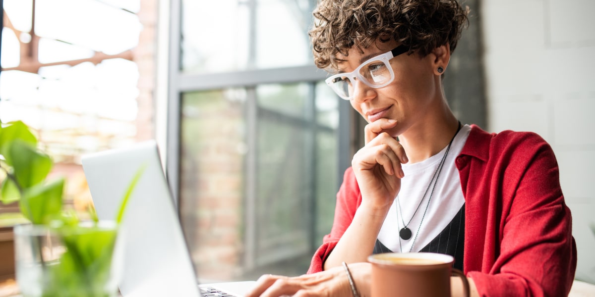 A marketing professional in side profile, working outside on a laptop