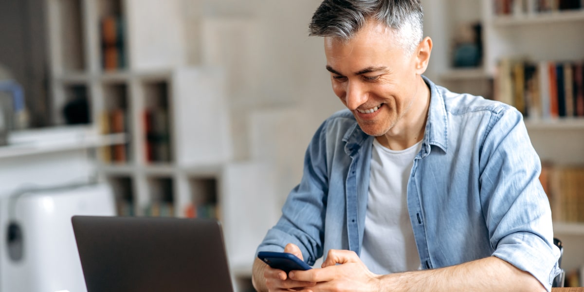 A social media manager holding a phone, posting something online