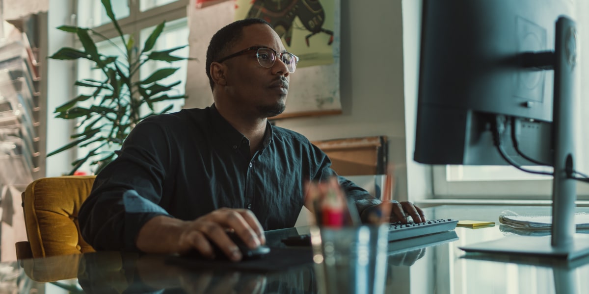 A social media specialist sitting at a desk, working on a desktop computer