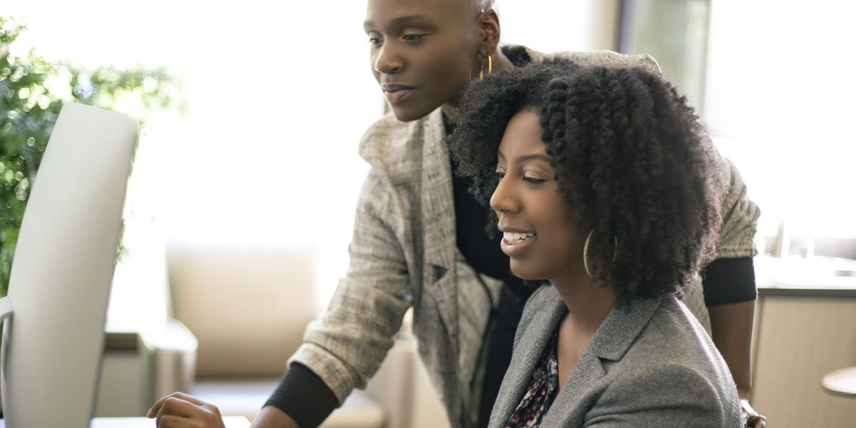 Two digital marketing specialists in front of a computer, looking at something on the screen