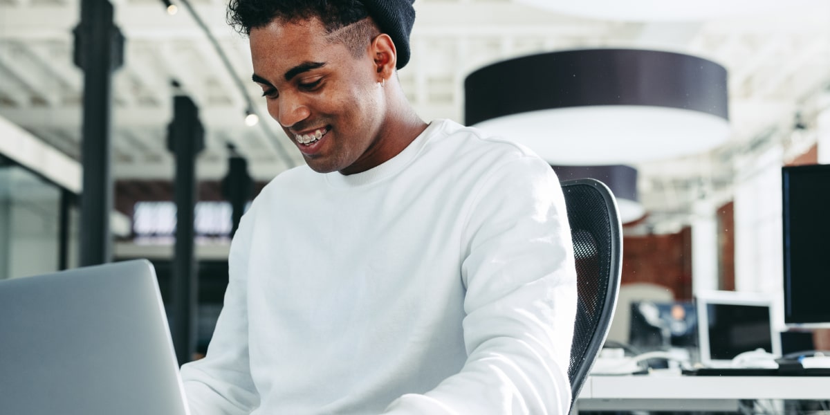 A social media specialist in a modern office, working on a laptop