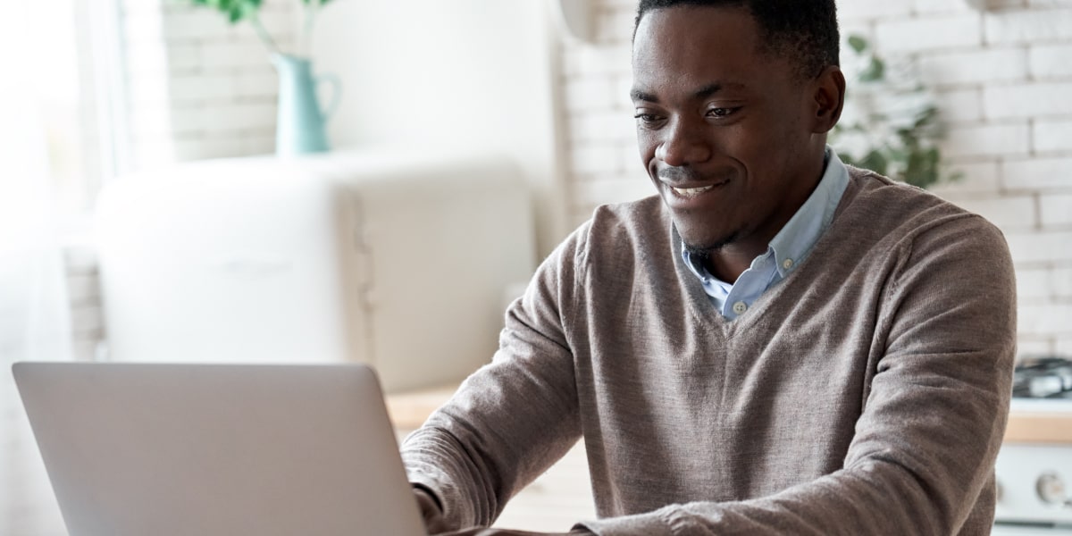 A digital marketing specialist sitting at a desk, working on a laptop, devising an omnichannel marketing strategy