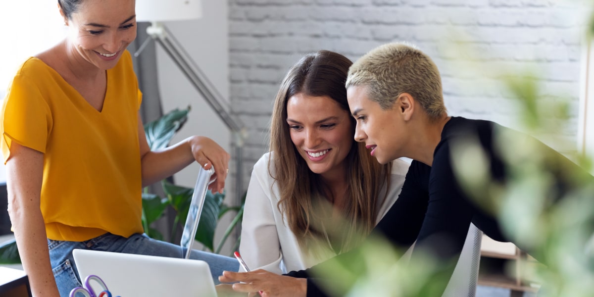 A social media specialist with two colleagues, showing them something on a computer screen