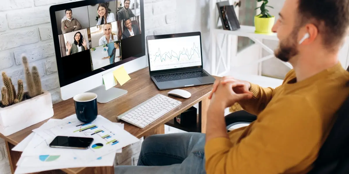 A digital marketing analyst sitting at a desk, having a meeting via a video conferencing tool