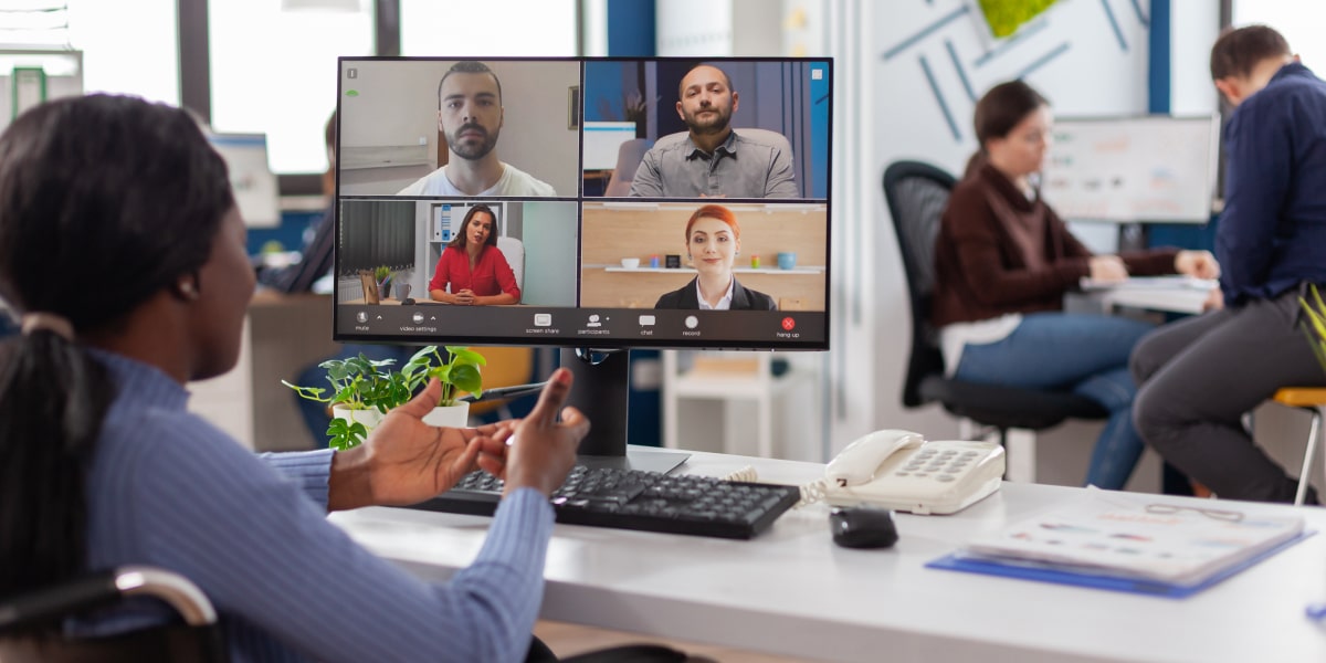 An aspiring digital marketing manager having a video call with other students on a big desktop computer 