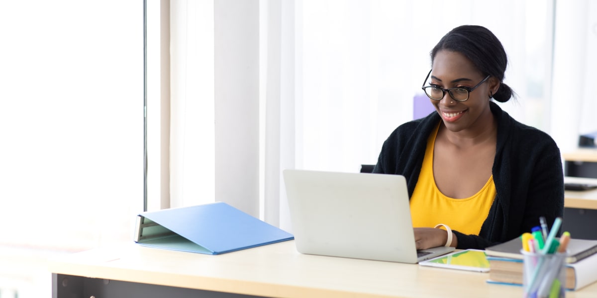 A digital marketing degree student sitting at a desk, working on a laptop