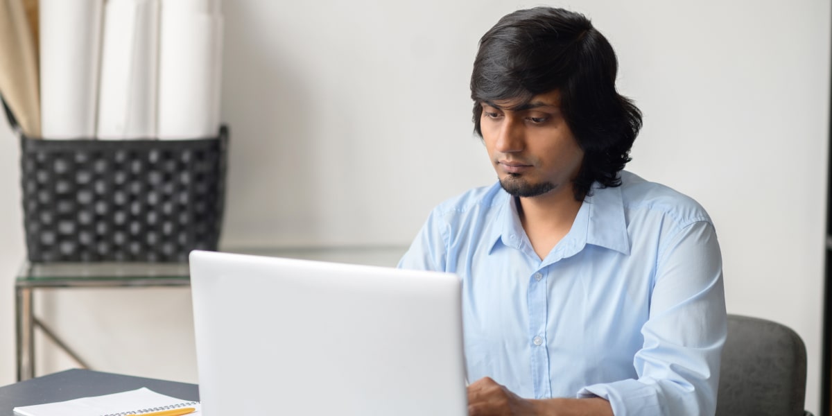 A marketer working on a laptop, devising a digital marketing strategy