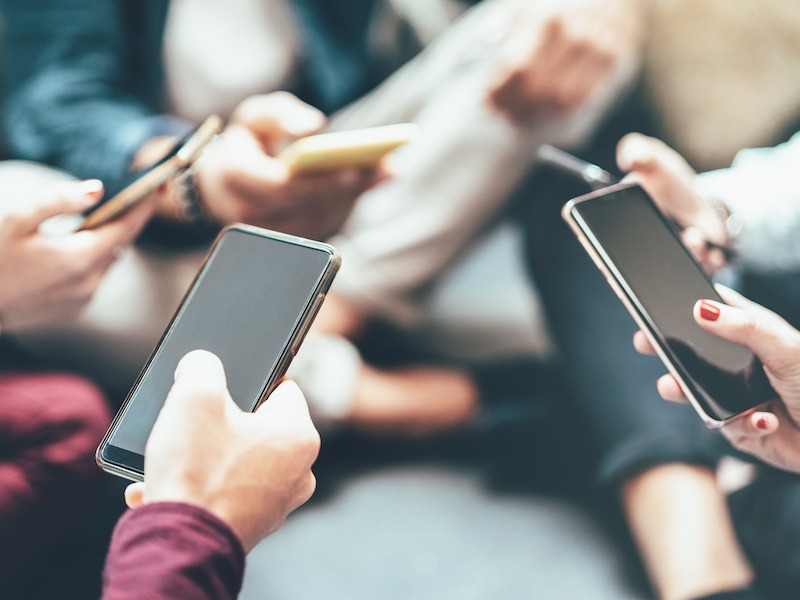 Group of people using social media on their smartphones