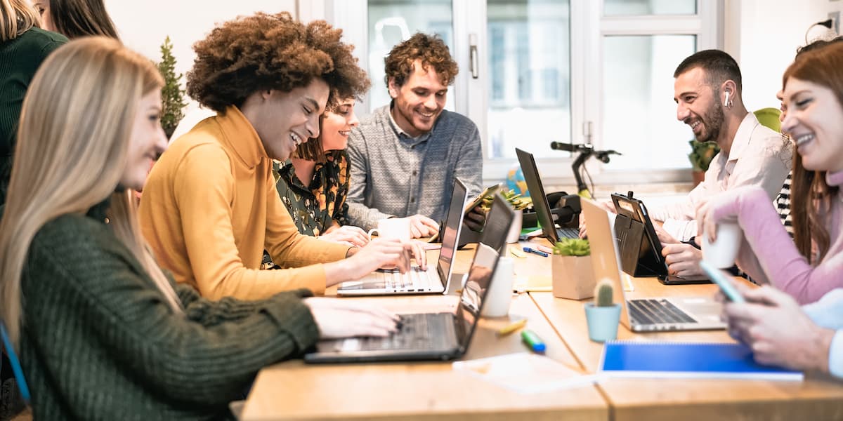 Freelancers sit at joined desks in a freelance work space