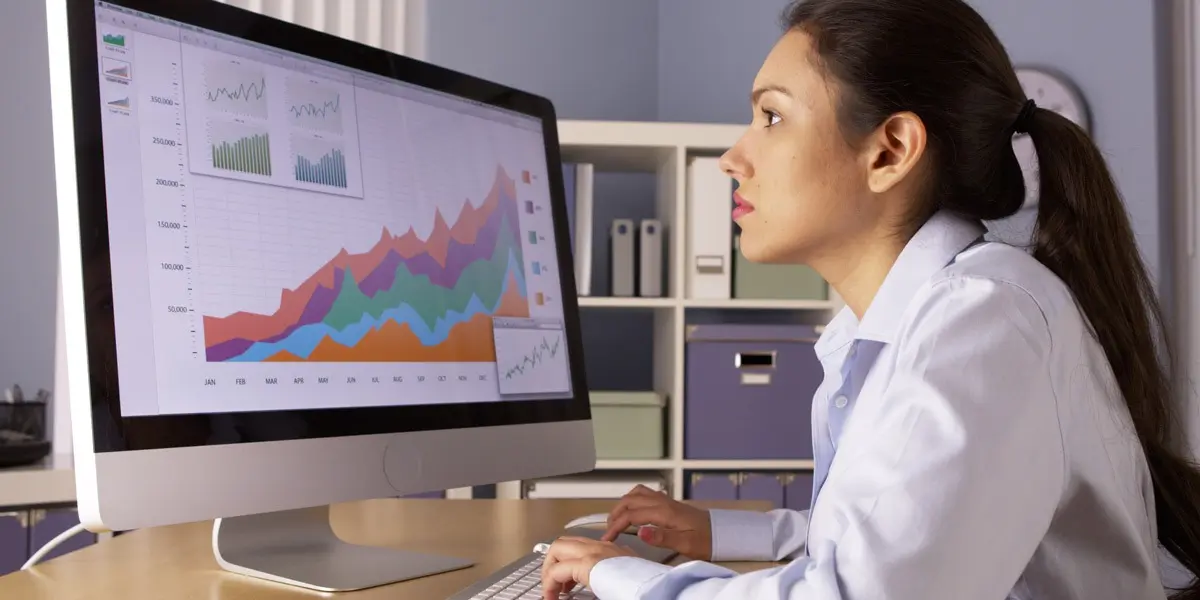 What is data analytics? A data analyst in side profile, looking at data visualizations on a screen