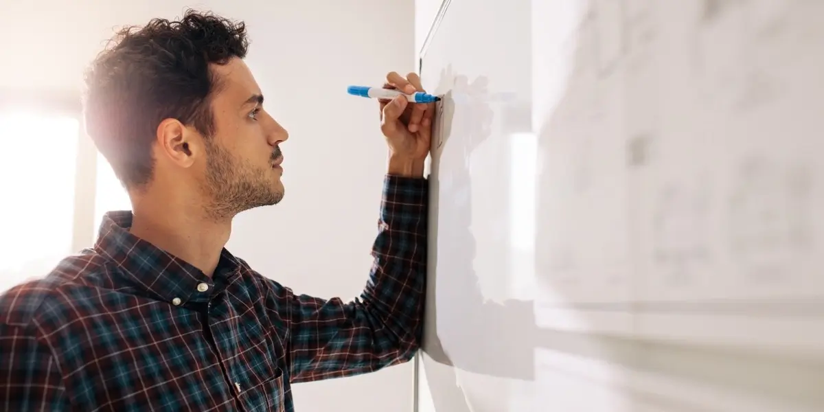 A UX designer drawing ideas out on a whiteboard