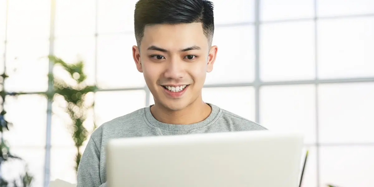 An aspiring marketer researching online digital marketing courses on a laptop