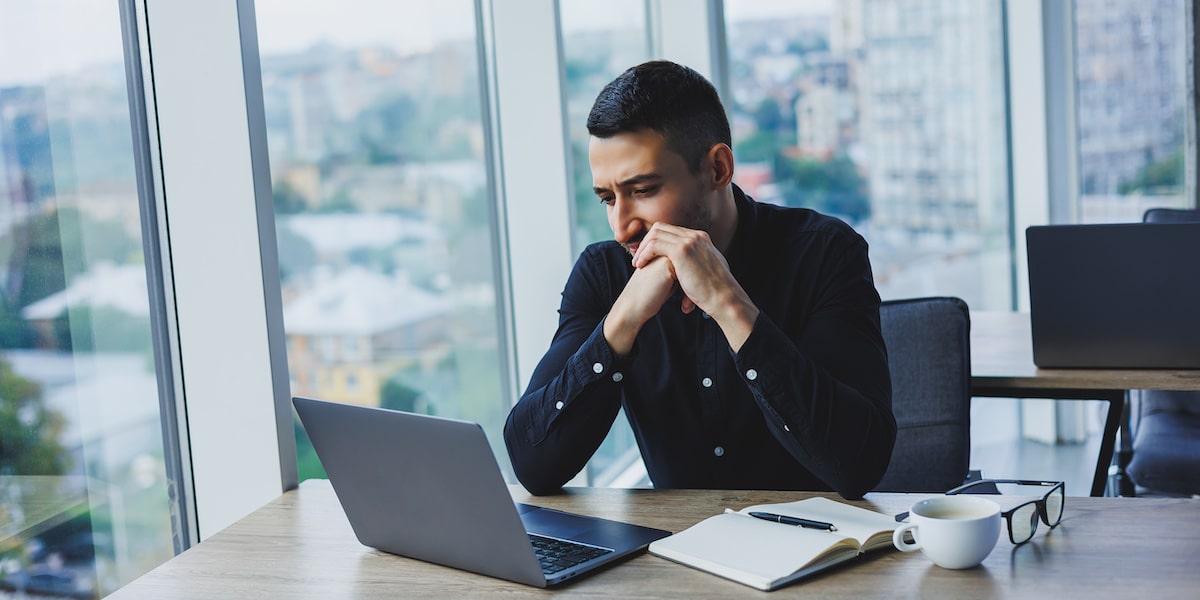 A machine learning engineer sits at his laptop in an open office.