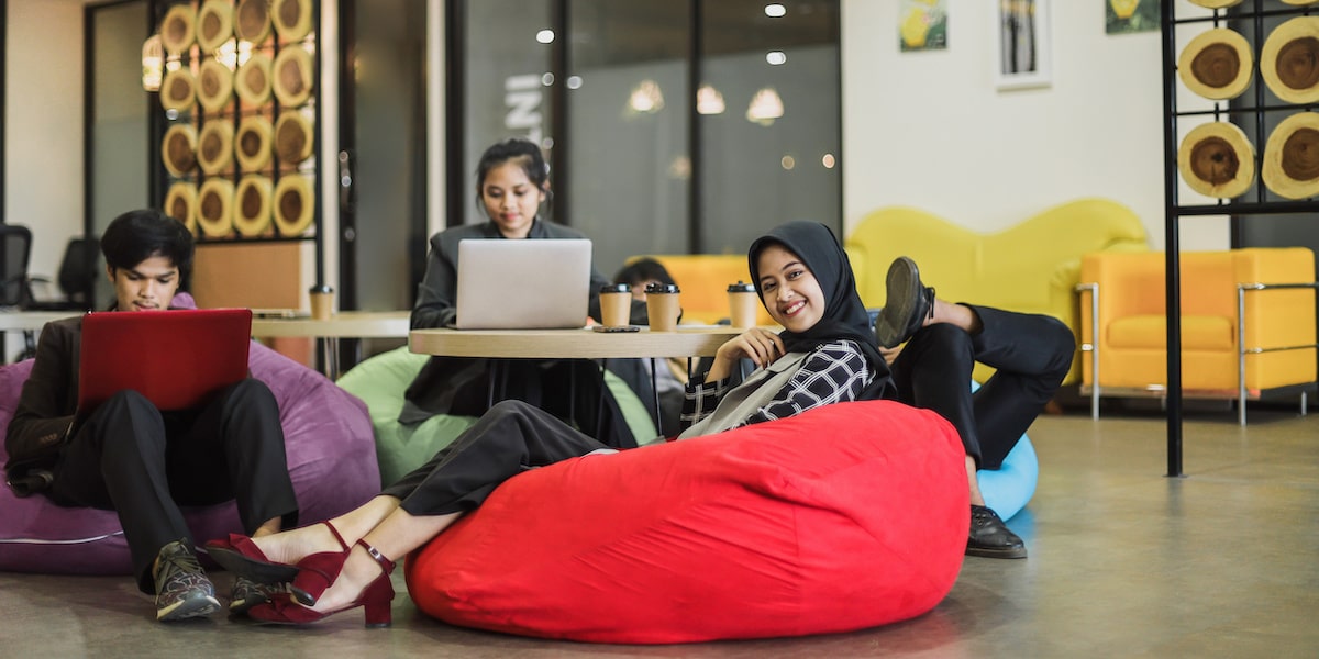 People earning a product manager salary in san francisco work on beanbags in an office.