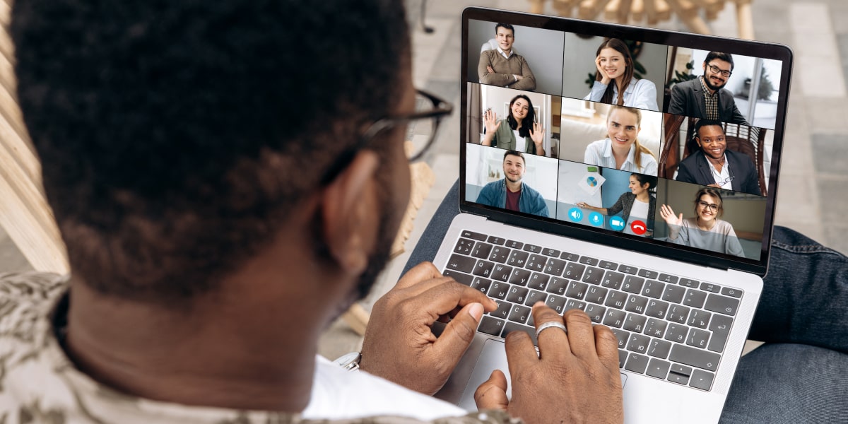 A data analyst attending a video conference on a laptop