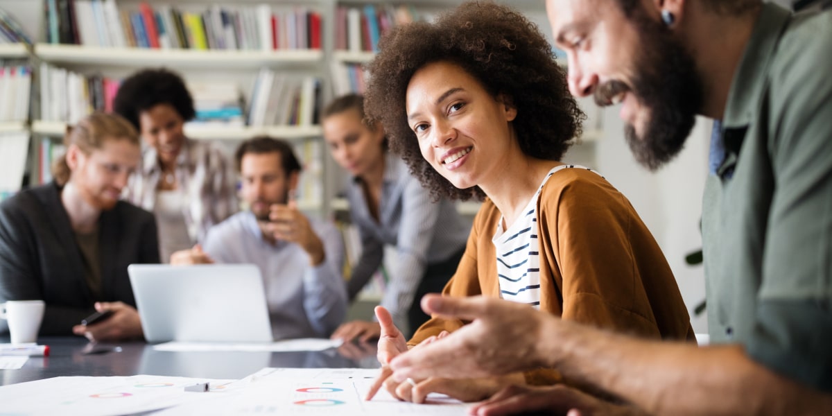 A group of data analysts sitting around a desk, working on a problem