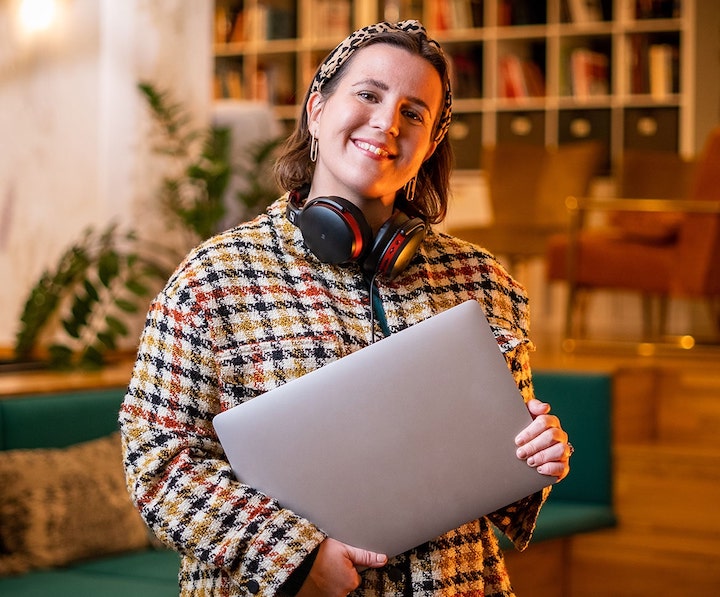 Girl working in tech holding a laptop