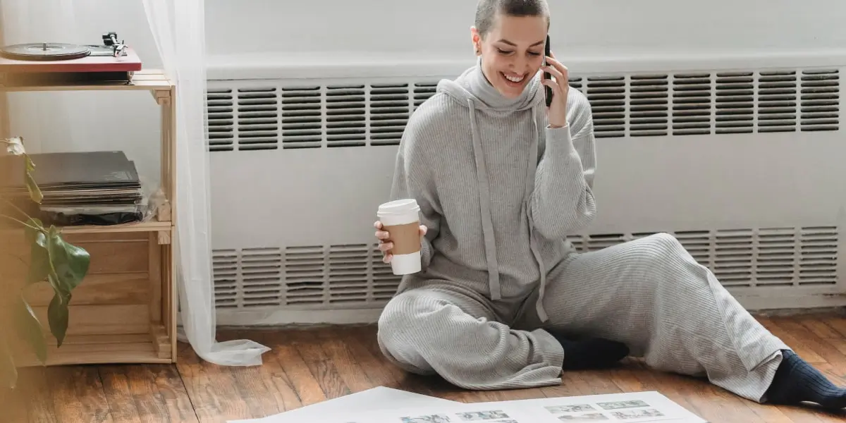 A UX designer sitting on the floor in their apartment, working on a passion project