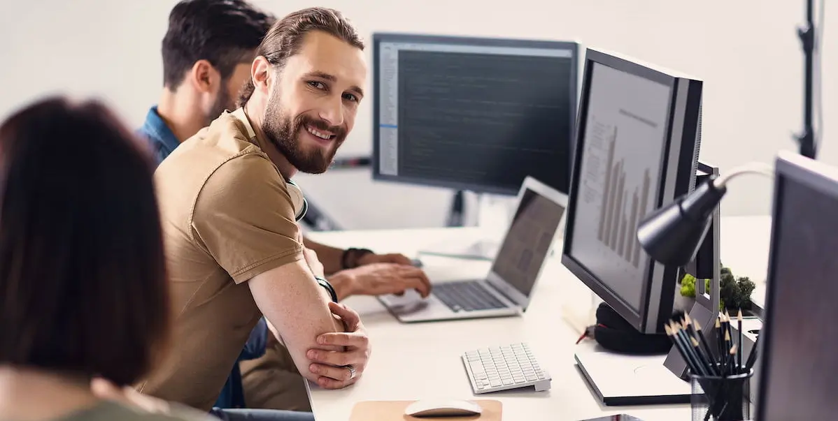 A student at one of many data analytics bootcamps pausing and smiling while working on a data visualization