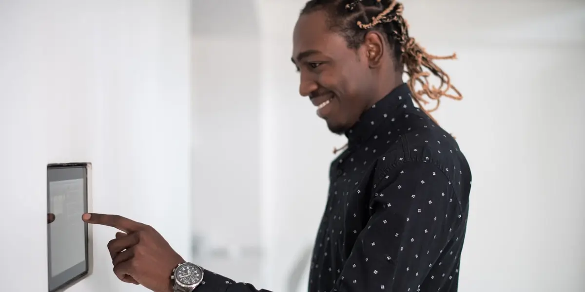 A person tapping buttons on a digital wall display