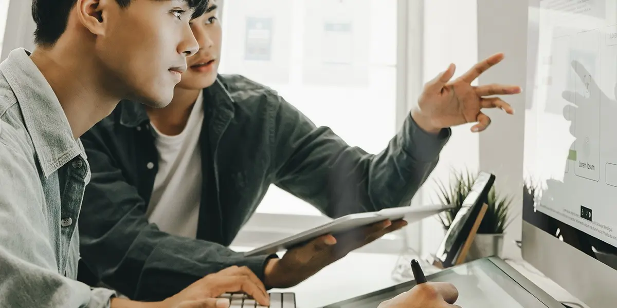 Two designers in side profile, looking at a whiteboard