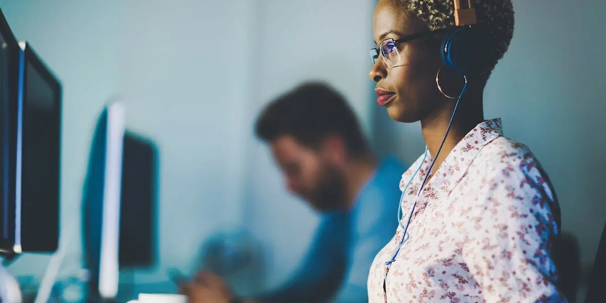 Woman sits at her computer comparing frontend vs backend development.