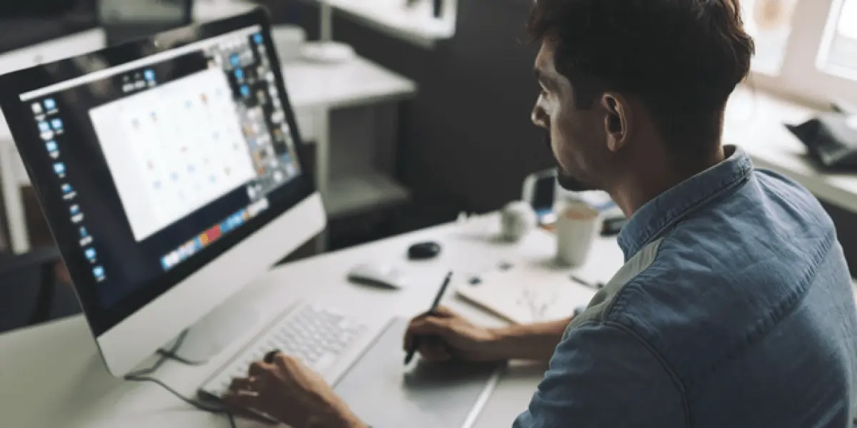 An animation designer in side profile, working on a desktop computer