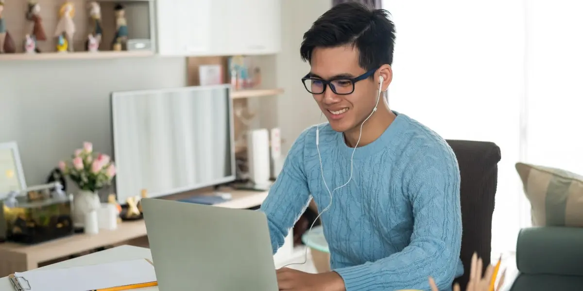 A data analyst sitting at a desk, looking at a computer screen
