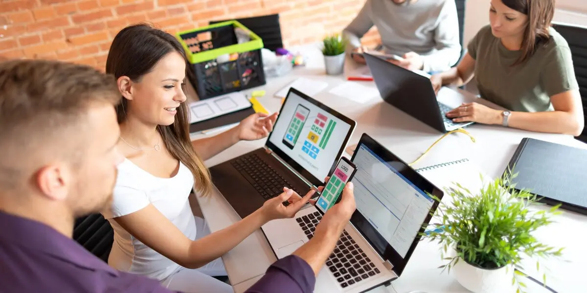 designers working on animation A group of designers working on laptops, looking at prototypes of a mobile app screen