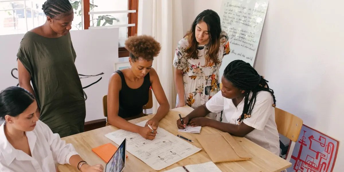 inclusivedesign uxdesign defineproblems min A diverse group of designers gathered around a table discussing inclusive design approaches