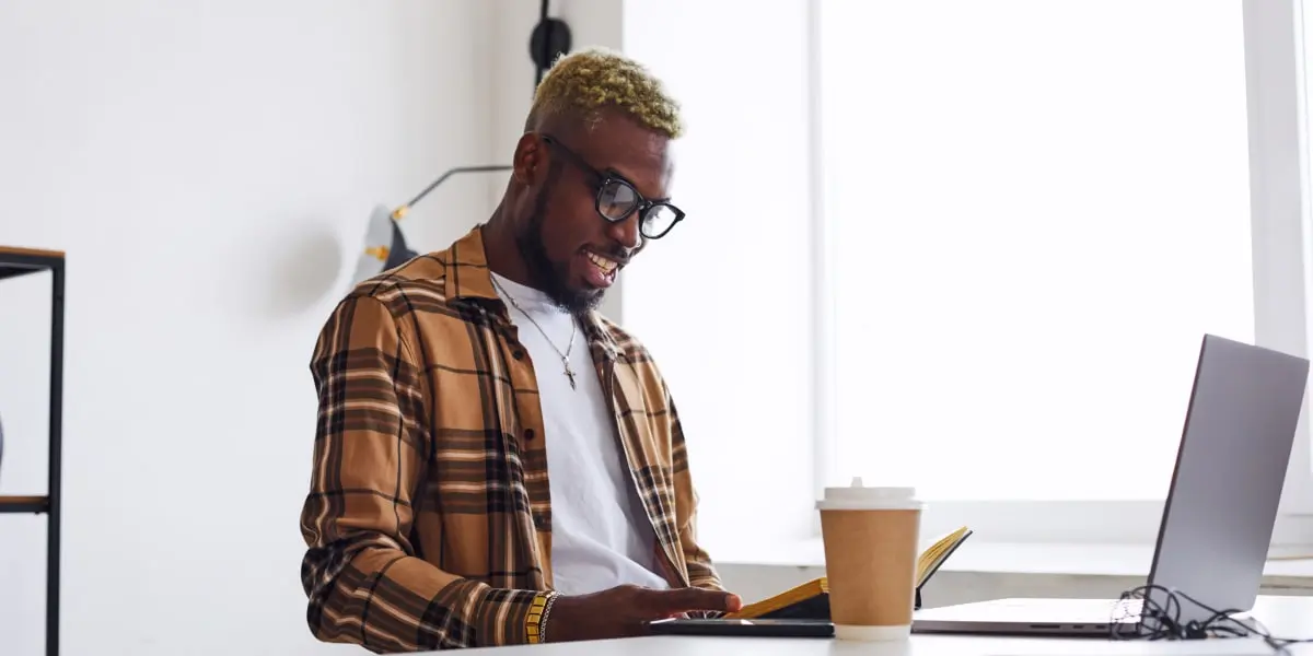 A startup worker sitting at a desk with a cup of coffee