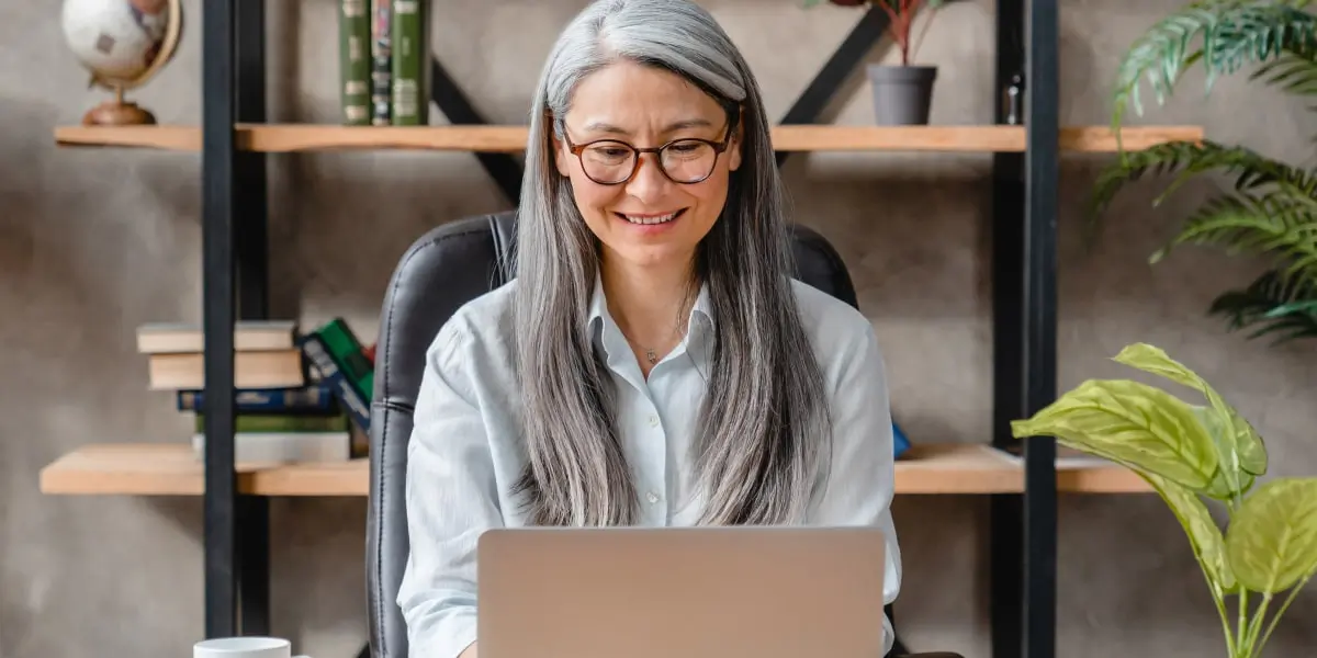 A person on a laptop, researching whether it is better to do a digital marketing internship or a course