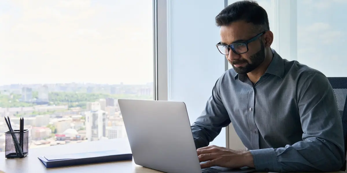 Entry-level data analyst works on a laptop in an office