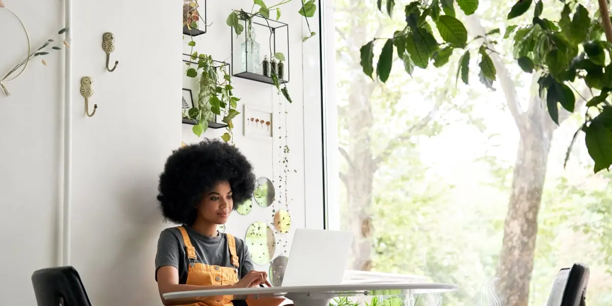 A digital marketing professional sitting at a desk, working on a laptop to create their marketing portfolio website