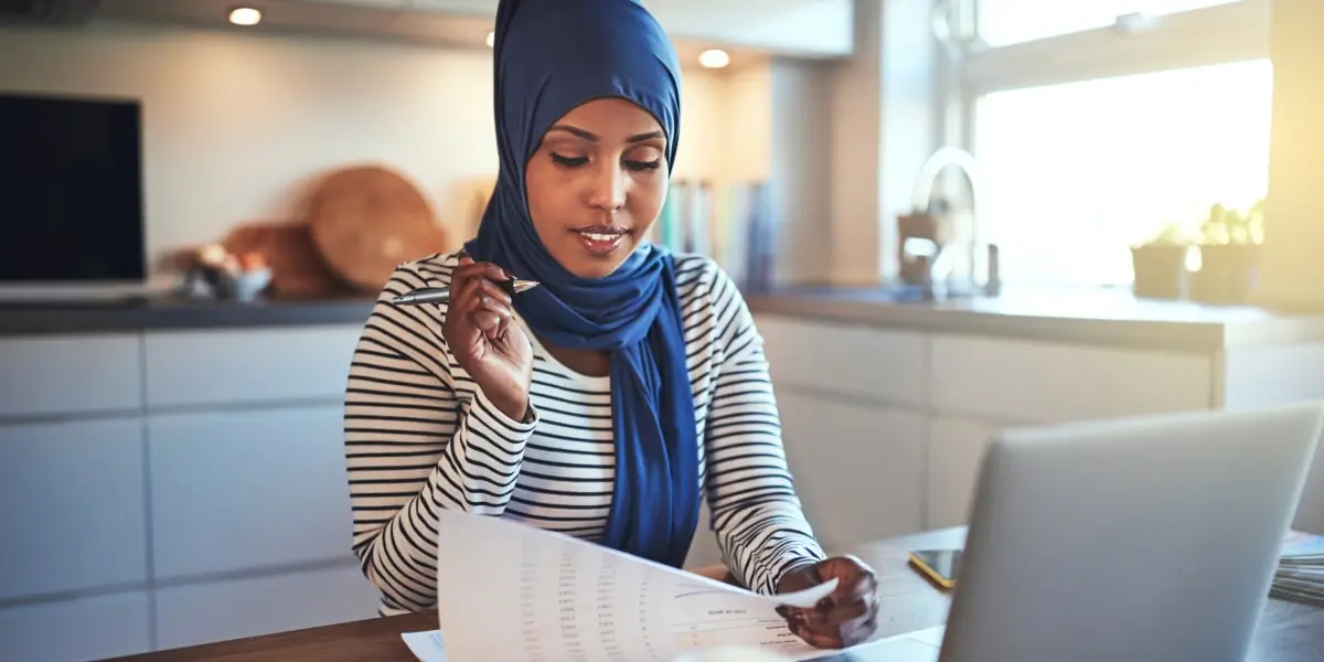 An SEO specialist sitting at a desk, looking through documents