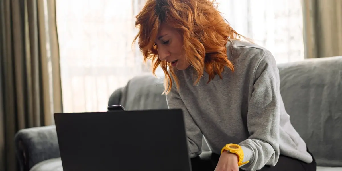 Social media specialist role A social media specialist sitting on a sofa, working on a laptop