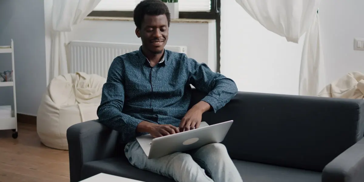 An SEO specialist sitting on a sofa with a laptop