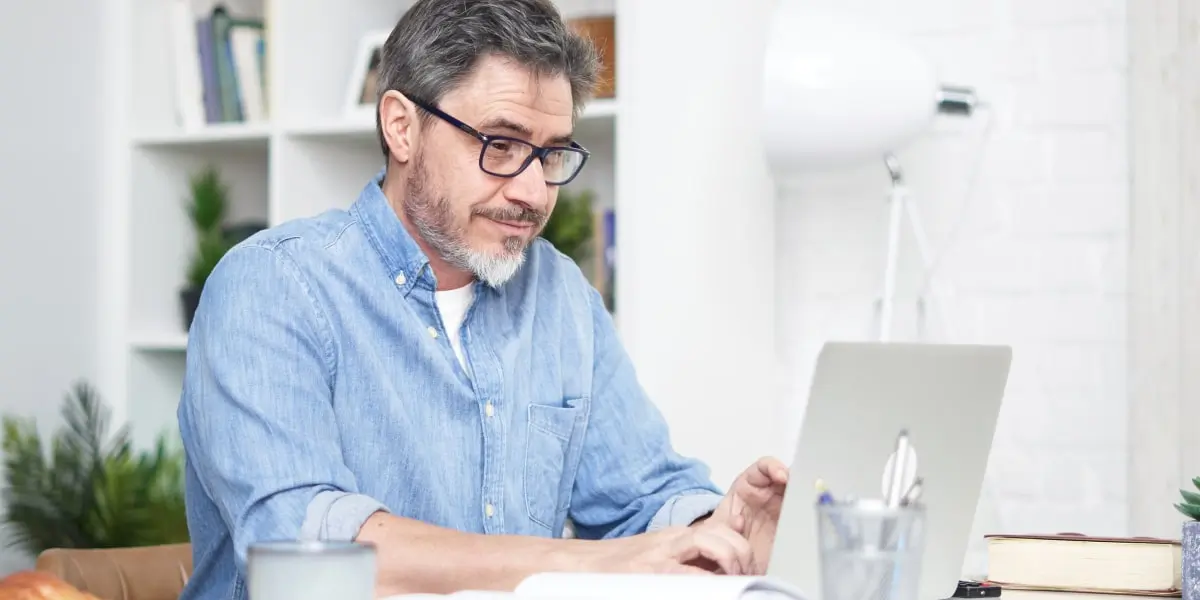 A person working from home, typing on a laptop