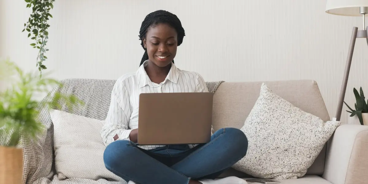 Digital marketing metrics and KPIs 1 A social media manager sitting on a sofa, working on a laptop