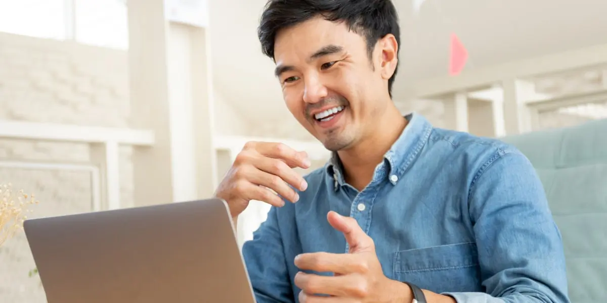 A freelance UX designer sitting at a desk, looking at a laptop