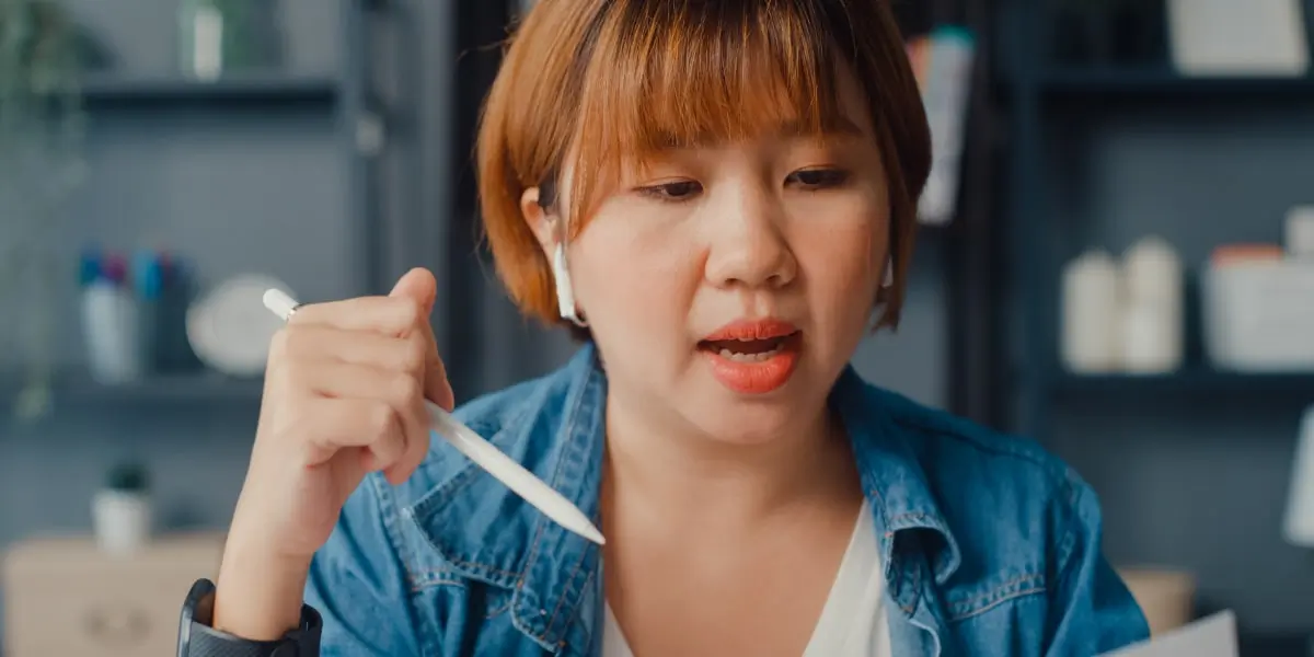 An aspiring career-changer sitting at a desk, holding a pen