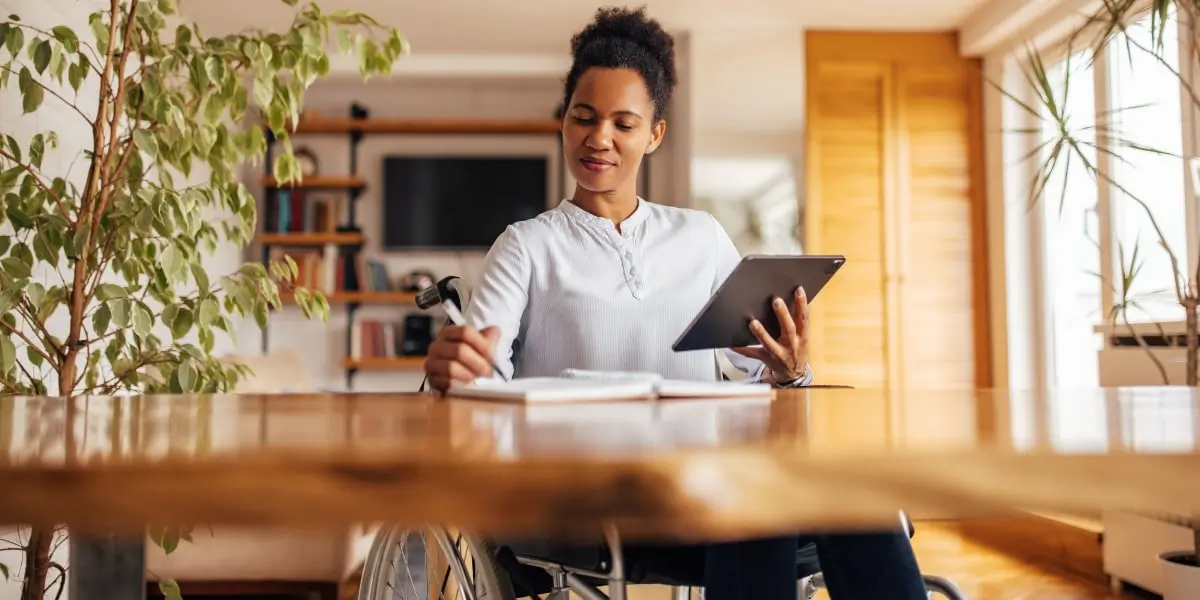 A career changer working from home, holding an iPad 