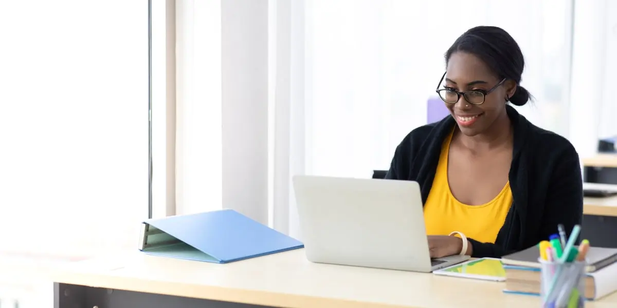 A digital marketing degree student sitting at a desk, working on a laptop