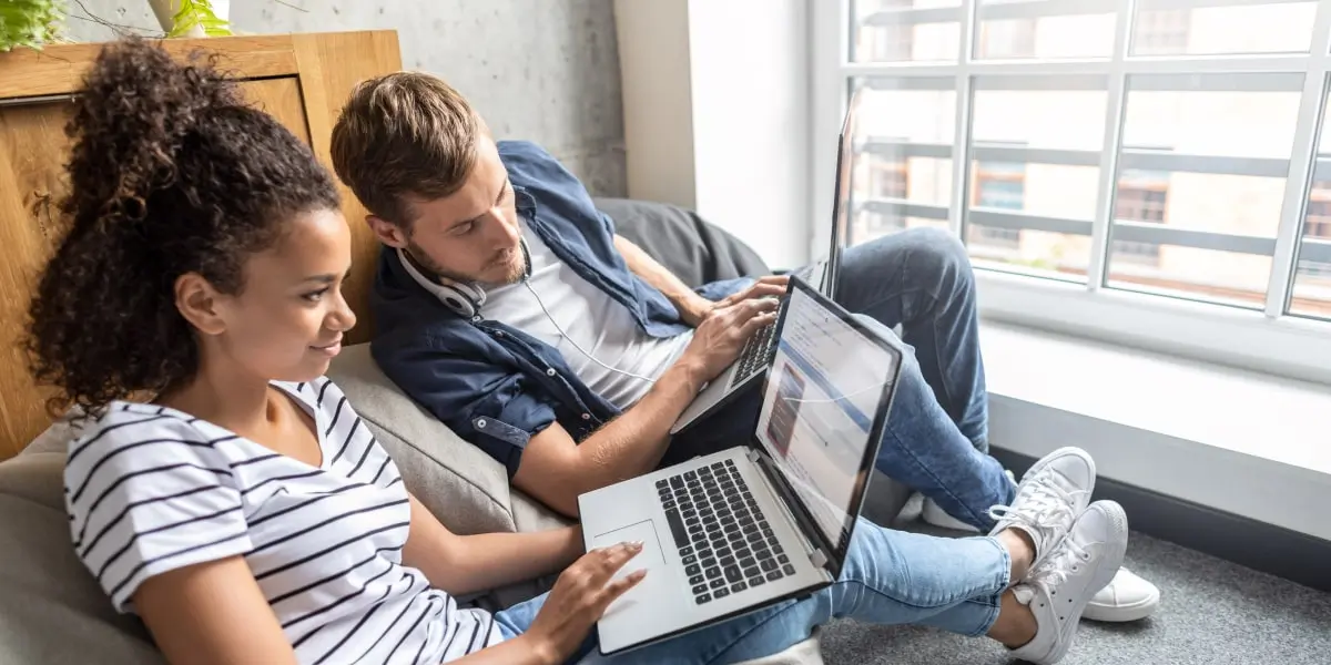 Two UX designers sitting on a beanbag, looking at a laptop