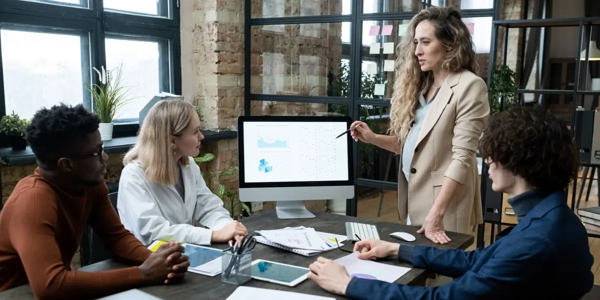 Pregnant woman in an office walking her team through the product management process.
